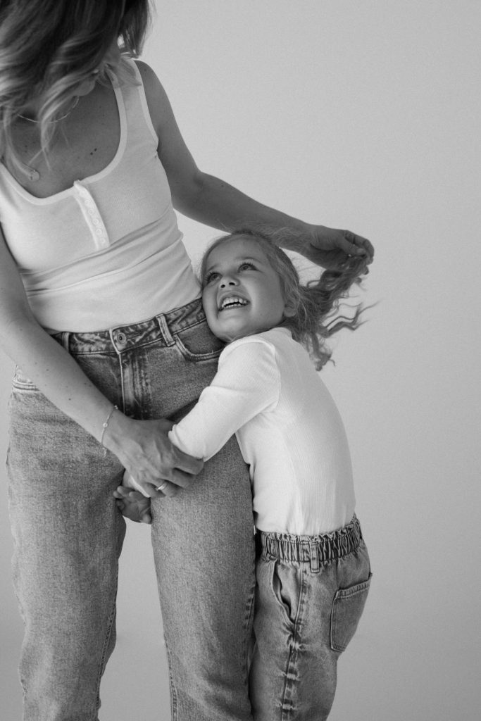 Authentisches Motherhood Portrait im Tageslichtstudio in Freiburg – vertrauter Moment zwischen Mutter und Tochter