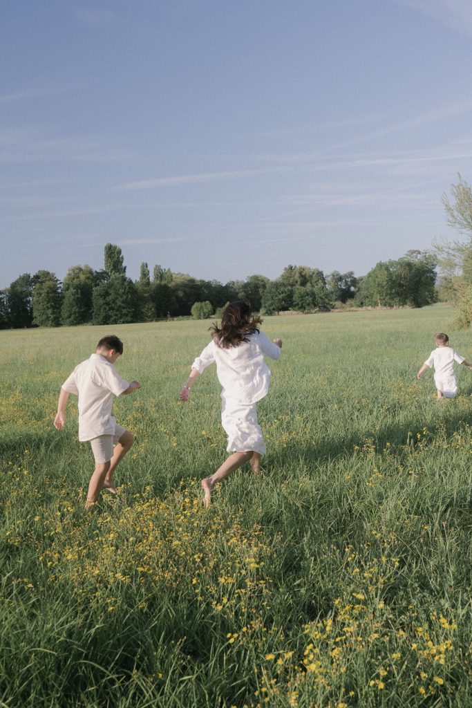 Kinder bewegen sich durch eine Wiese bei einem Outdoor Familienshooting in Freiburg